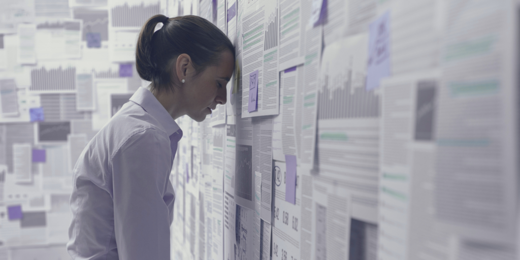 Frustrated business analyst overwhelmed by excessive data, highlighting the risks company in software development projects
